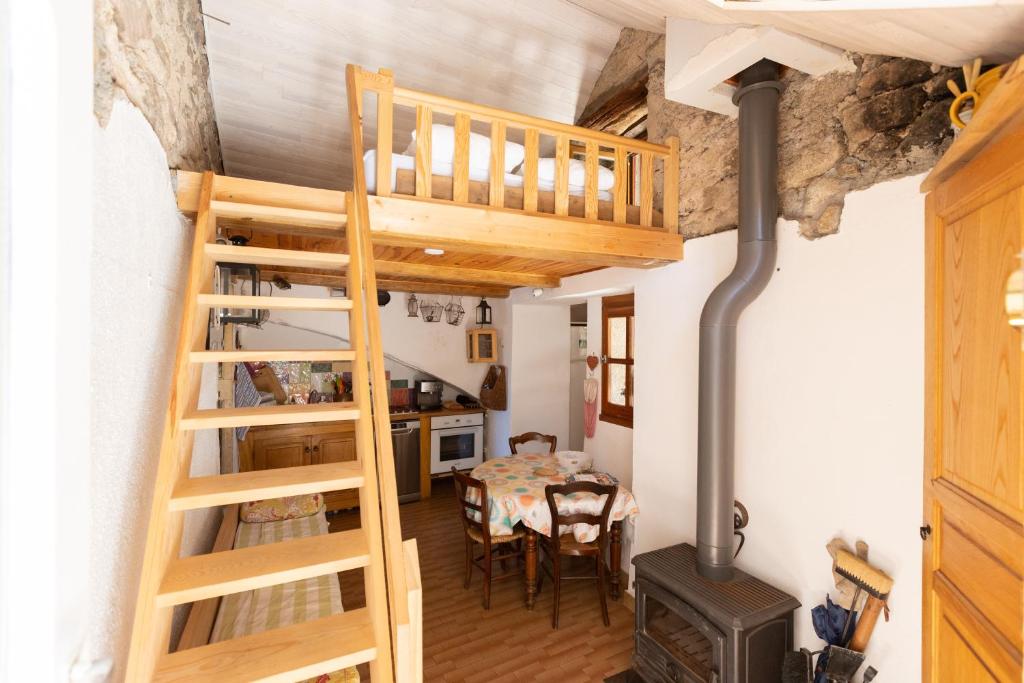 a room with a staircase and a table and a stove at Gîte en Cévennes Le Pont de Montvert Sud Mont Lozère in Le Pont-de-Montvert