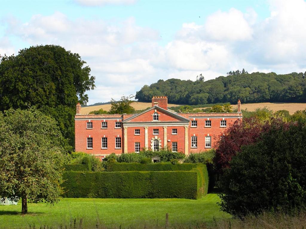 um grande edifício de tijolos vermelhos com árvores em frente em 10 Castle St em Cranborne