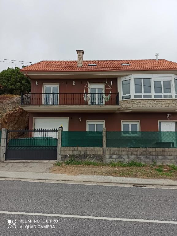 une maison rouge sur le côté d'une rue dans l'établissement CASA CON ESPECTACULARES VISTAS AL MAR, à Escarabote