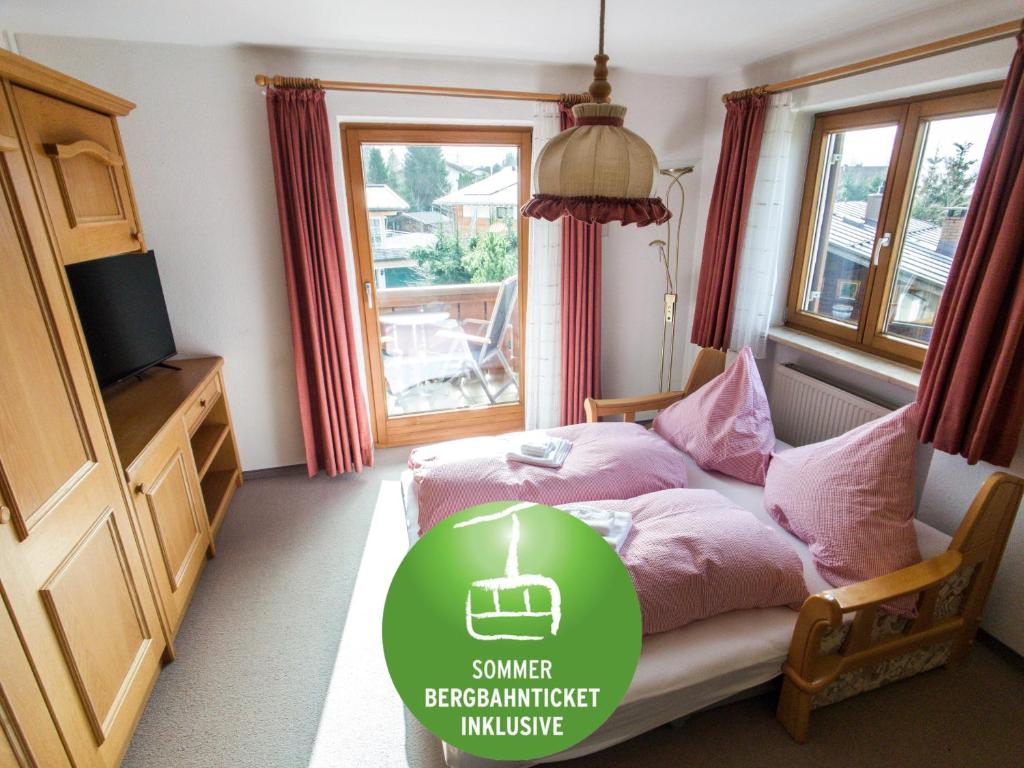 1 dormitorio con cama con sábanas rosas y ventana en BERGFEX Gaisalphorn mit Sommer-Bergbahnticket, en Oberstdorf