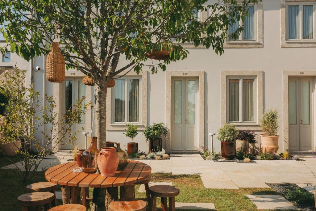 a patio with tables and stools in front of a building at Village Aparthotel By BOA in Porto