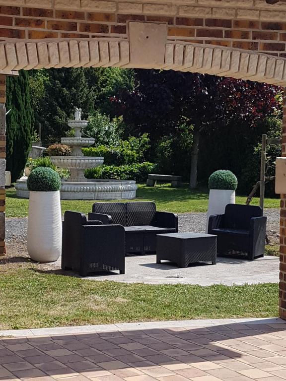 een groep stoelen onder een paviljoen in een park bij Domaine de karoli in Barneville-sur-Seine