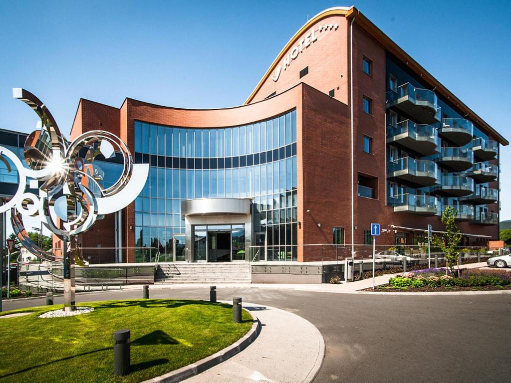 a building with a sculpture in front of it at Hotel Vitality in Vendryně