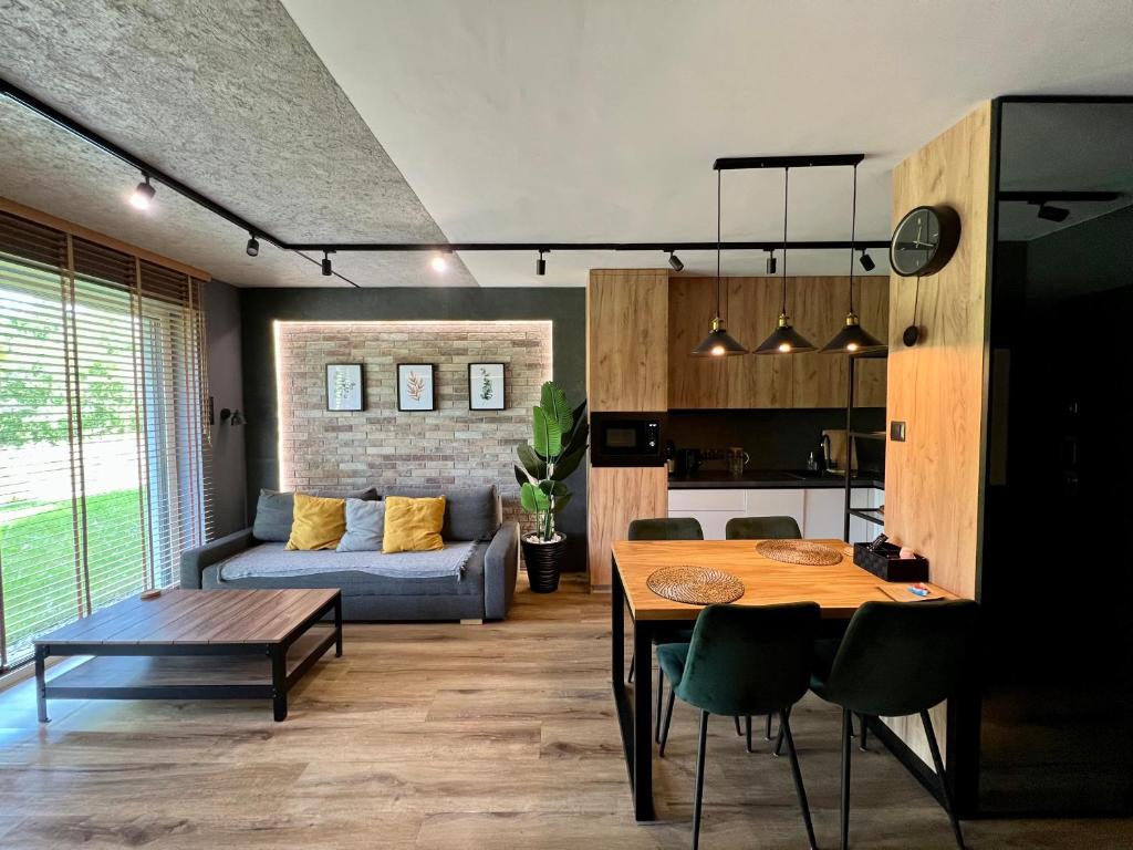 salon ze stołem i kanapą w obiekcie Loft Klonowa - Apartament z garażem w Kielcach
