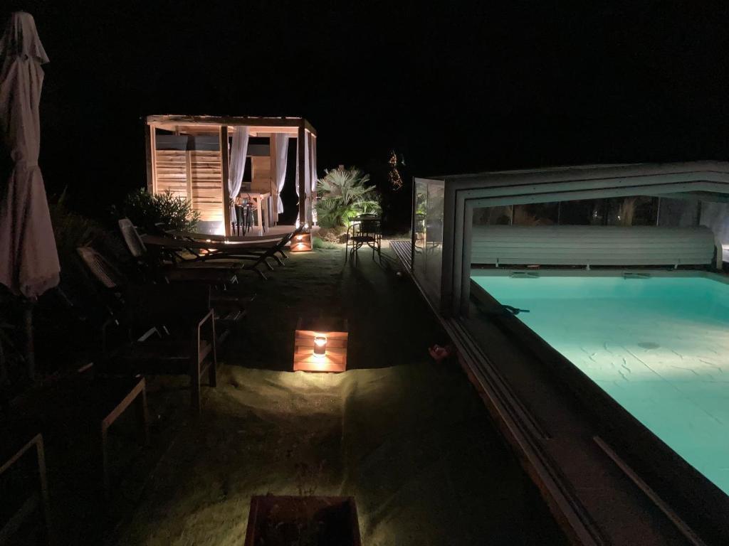 a swimming pool at night next to a house at Desirad in La Clisse