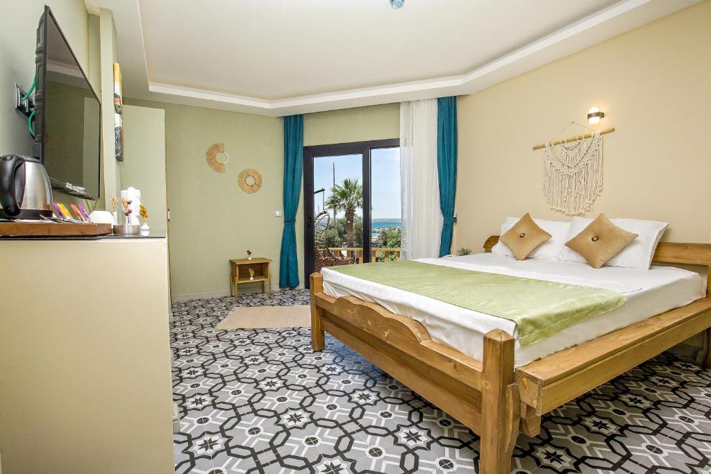 a bedroom with a large bed and a kitchen at Dimora Boemo Hotel in Didim