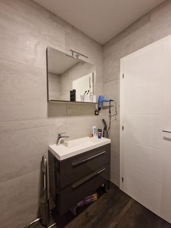uma casa de banho com um lavatório e um espelho em Wellness apartment BLACK-WHITE em Široki Brijeg
