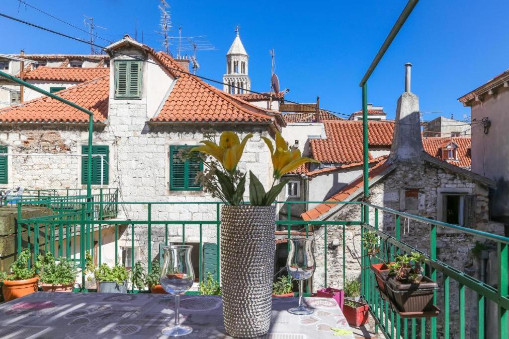 een balkon met een tafel met 2 wijnglazen bij Apartment PALACE OLD TOWN with TERACCE in Split