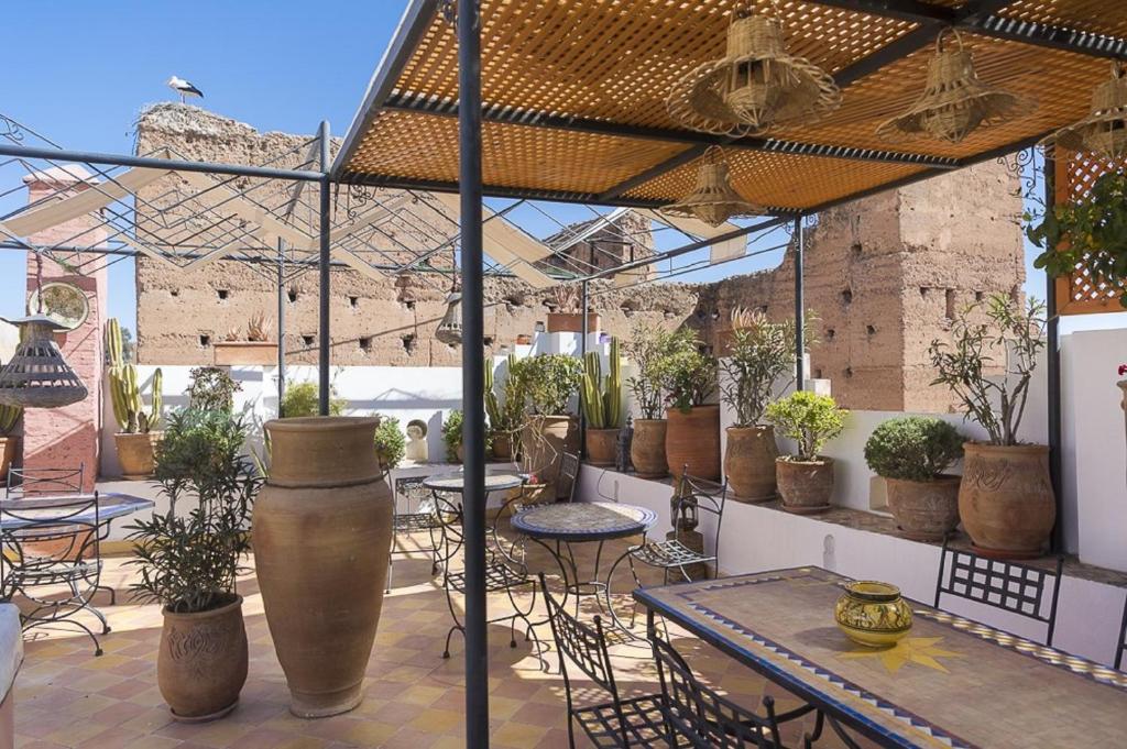 een patio met tafels en stoelen en potplanten bij Riad Maison Arabo-Andalouse in Marrakesh