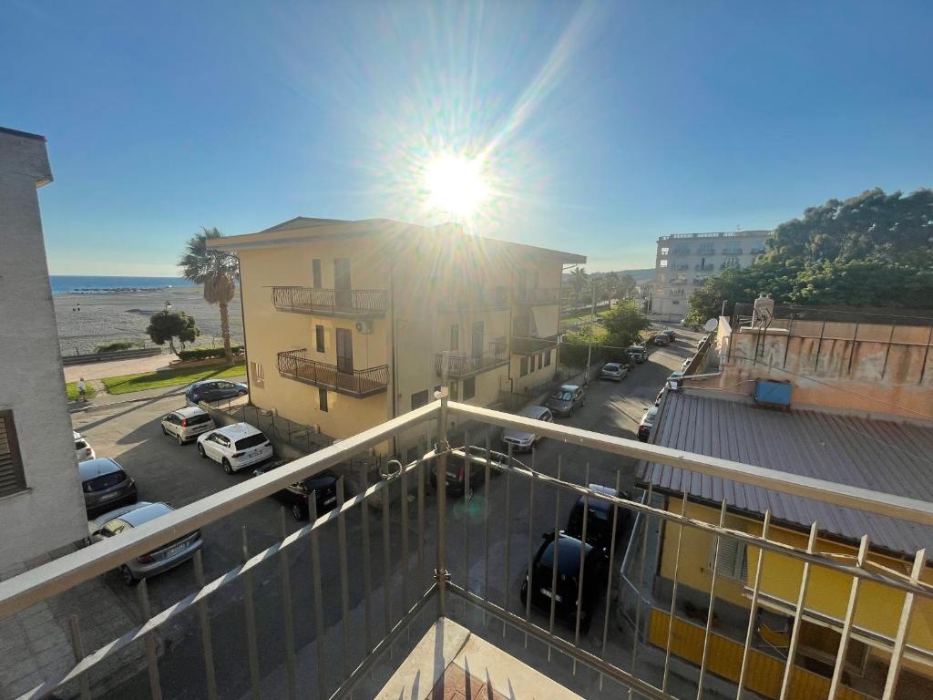 un balcón con el sol brillando en un edificio en Wind House, en SantʼEufemia Lamezia