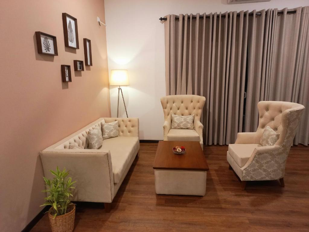 庫魯內格拉的住宿－NINETY-NINE APARTMENTS，客厅配有两把椅子、一张沙发和一张桌子