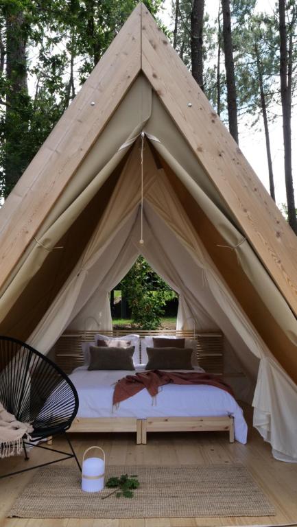 a tent with a bed in the middle at Amaraxe Ecoglamping in Miñortos