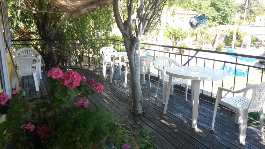 una mesa blanca y sillas en una terraza con flores en Posada Los Balnearios en San Pedro