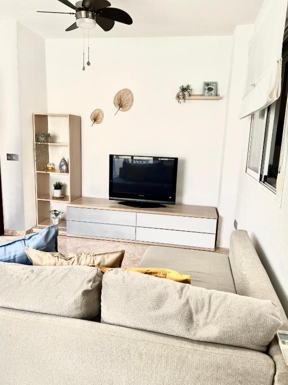 - un salon avec un canapé et une télévision dans l'établissement Precioso apartamento, à Malaga