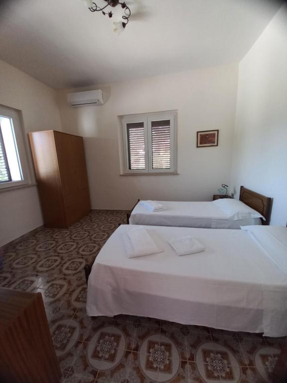 a hotel room with two beds and two windows at Tenuta Aquilae in Castrofilippo