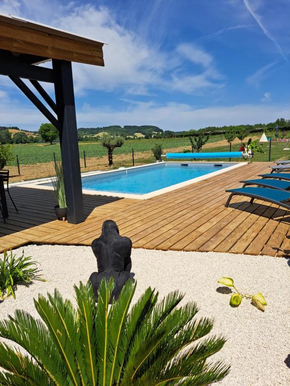 uma piscina com um deque de madeira ao lado em Le Domaine Vesque em Saint-Pierre-de-Clairac