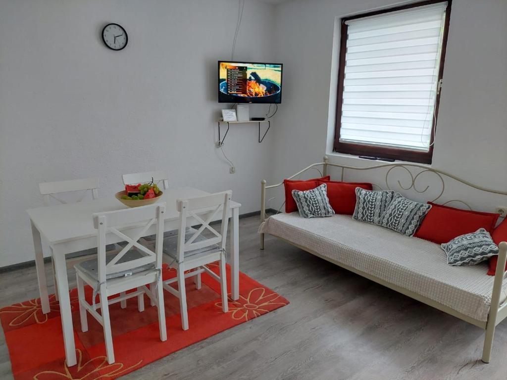 een woonkamer met een bank, een tafel en een tv bij Apartman Emanuel in Jajce