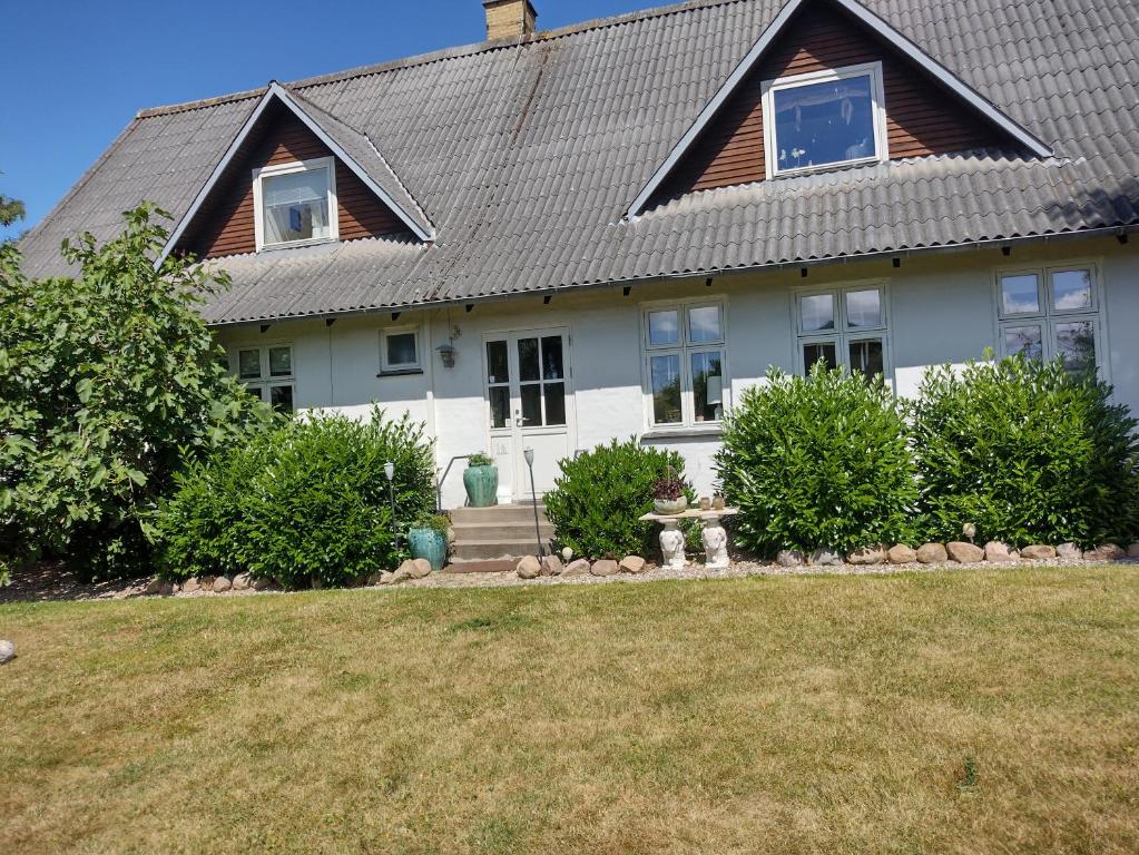 une maison blanche avec un toit en gambrel dans l'établissement Den Gamle Apotekergaard, à Høng