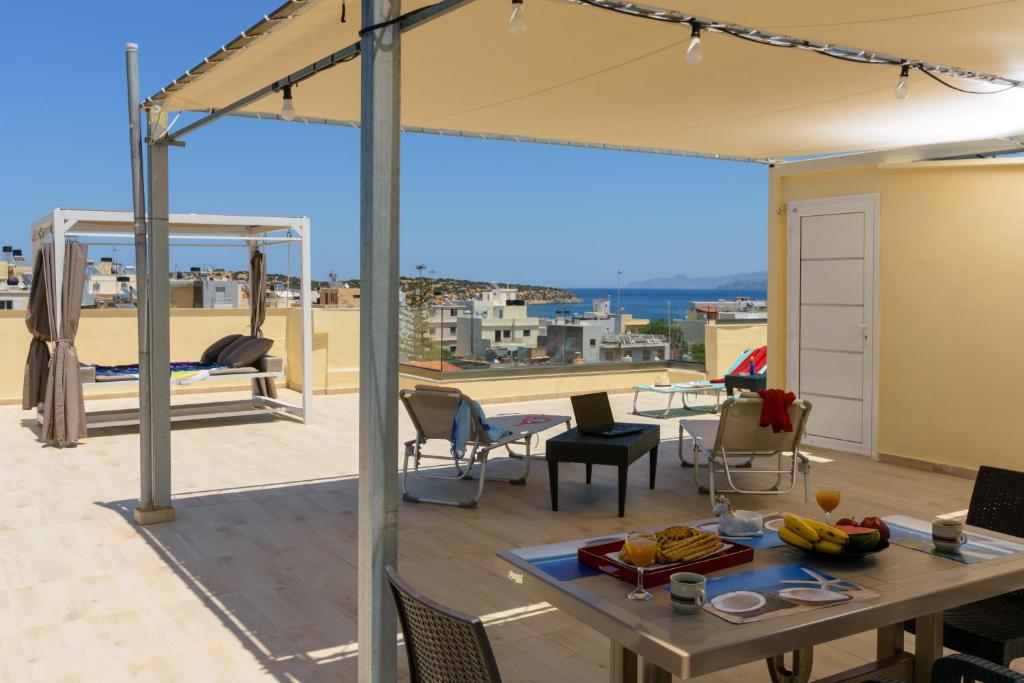 d'une terrasse sur le toit avec une table et des chaises. dans l'établissement HOUSE FOR FAMILIES NEAR THE LAKE, à Agios Nikolaos