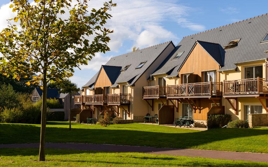 ein großes Apartmenthaus mit Balkon und Hof in der Unterkunft Lagrange Vacances Les Roches Douvres in Saint-Briac-sur-Mer