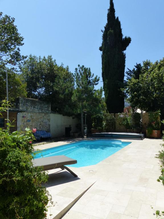 a swimming pool with a bench in a garden at Maisonnette proche des calanques , les Bruyères in Marseille