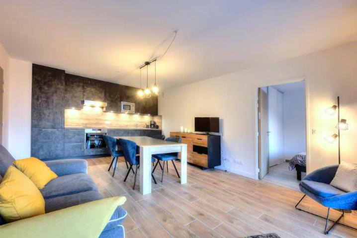 a living room with a table and chairs and a kitchen at Appartement 60M2 - TELECABINE SAINT GERVAIS - 201 in Saint-Gervais-les-Bains