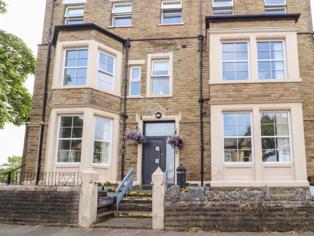 una casa de ladrillo con puerta negra y ventanas blancas en 112 Balmoral Road, en Morecambe