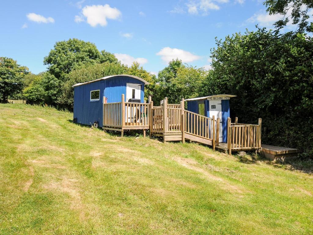 dos cabañas portátiles en un campo junto a los árboles en Shepherds Hut, en Lostwithiel