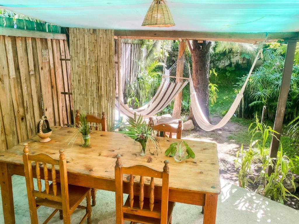 a dining room with a wooden table and a hammock at Unicorn Reborn - Peaceful Rentals in San Marcos La Laguna