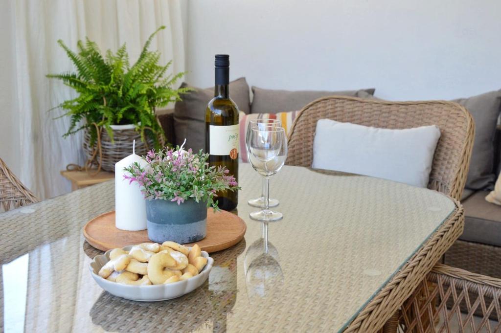 a table with a bottle of wine and a glass at Apartman Paula in Milna