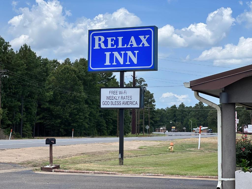 una señal azul de la posada de relajación al lado de una carretera en Relax Inn Ashdown, en Ashdown