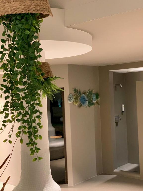 a large white vase with a plant in a room at Hotel Saalbacher Hof in Saalbach-Hinterglemm