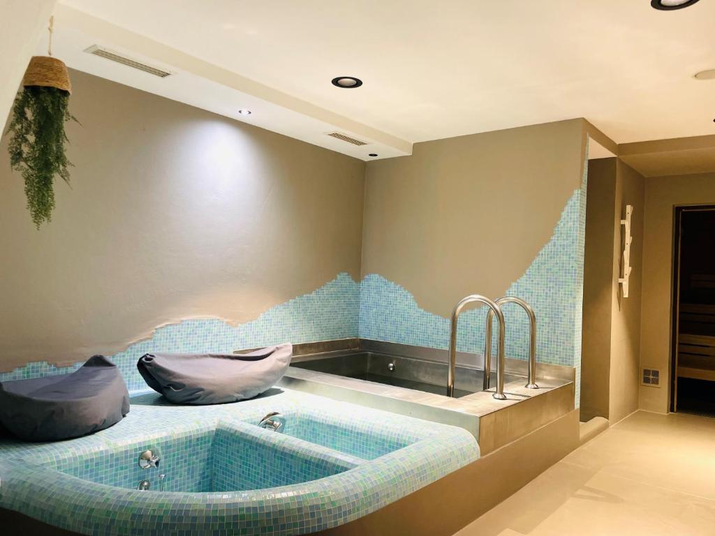 a bath tub with two faucets in a bathroom at Hotel Saalbacher Hof in Saalbach-Hinterglemm