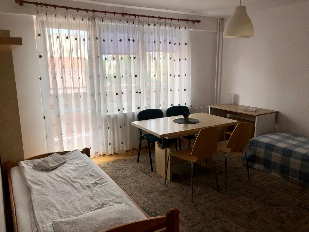 a room with a table and chairs and a bed at Słoneczny Apartament 3 - oddzielne pokoje Centrum Jarot in Olsztyn