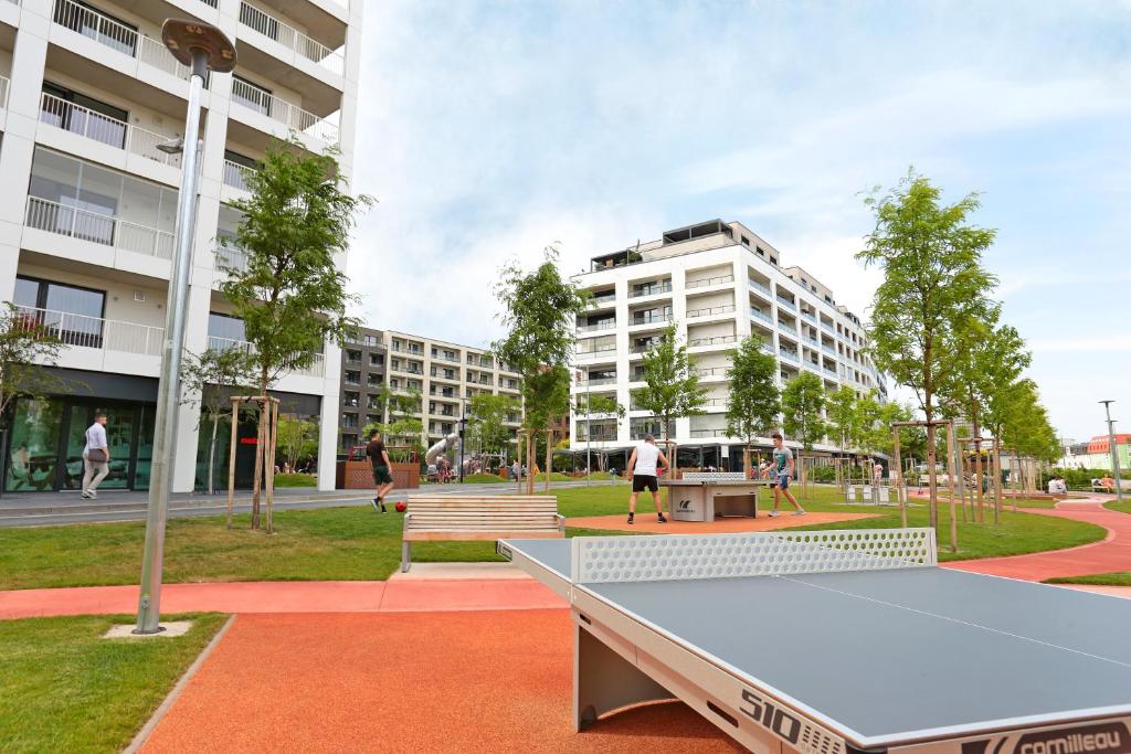 a ping pong table in a park with buildings at Modern apartment near the city centre URBAN in Bratislava