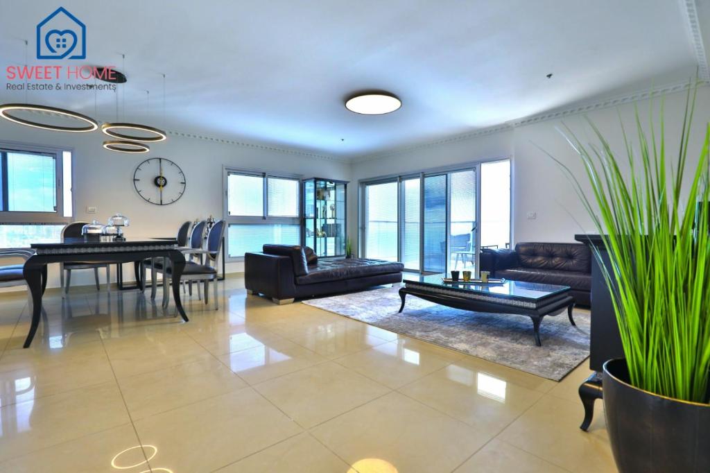 een woonkamer met meubilair en een tafel bij Sea view family relax apartment in Netanya