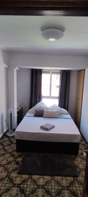 a bedroom with a large bed with a large window at Habitación doble cerca al centro. in Valencia