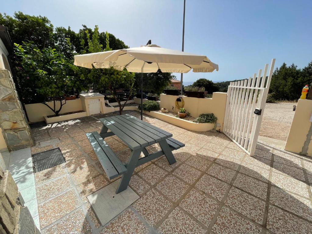 a picnic table with an umbrella on a patio at Casa Cioppy in Cala Gonone