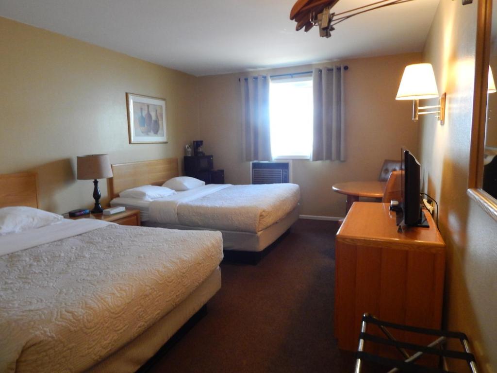 a hotel room with two beds and a television at Alpine Inn in Pagosa Springs
