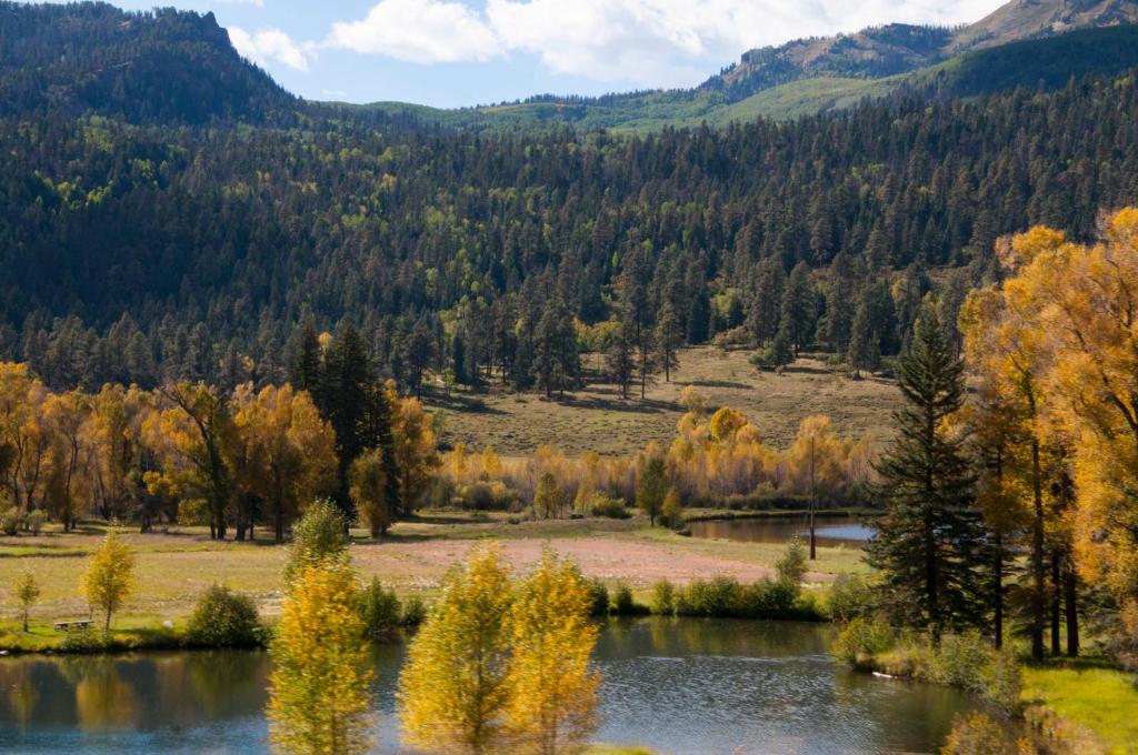 a lake in the middle of a valley with trees at Alpine Inn in Pagosa Springs