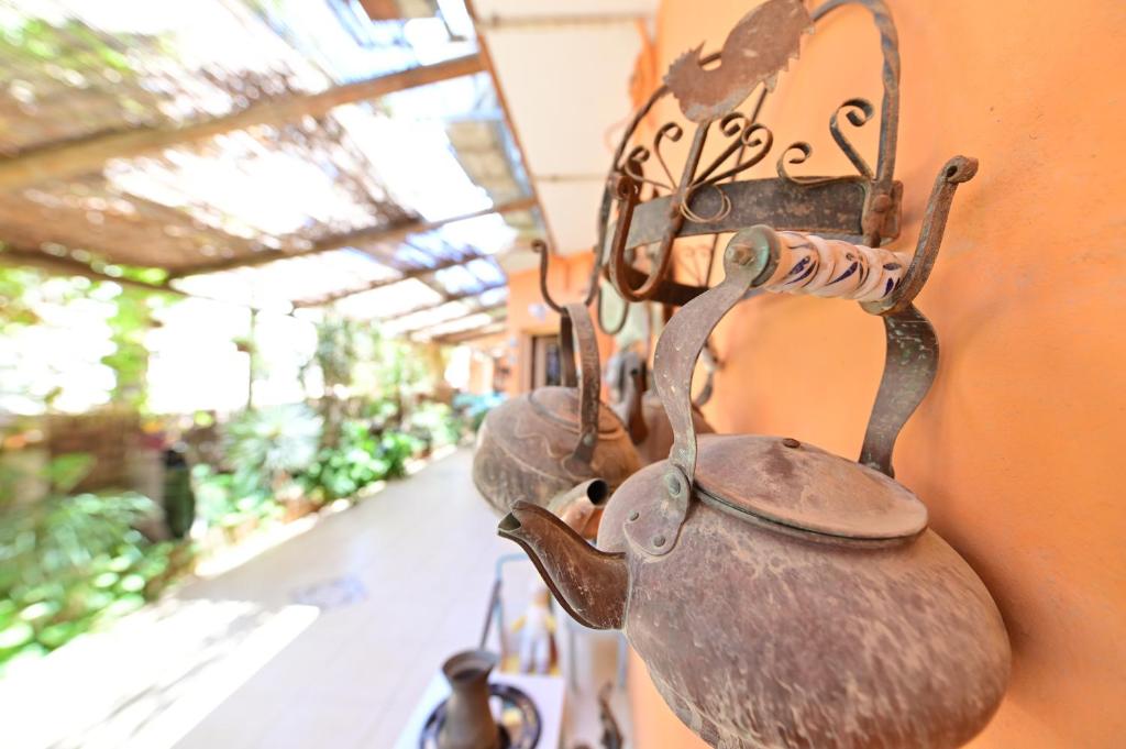 a group of tea pots hanging on a wall at Sweet Home, Only 7 Min to the beach - By SEAELO EILAT in Eilat