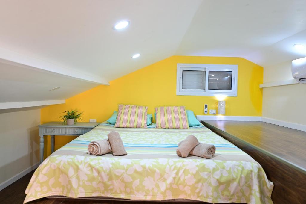 a bedroom with a large bed with two pillows on it at Sweet Home, Only 7 Min to the beach - By SEAELO EILAT in Eilat