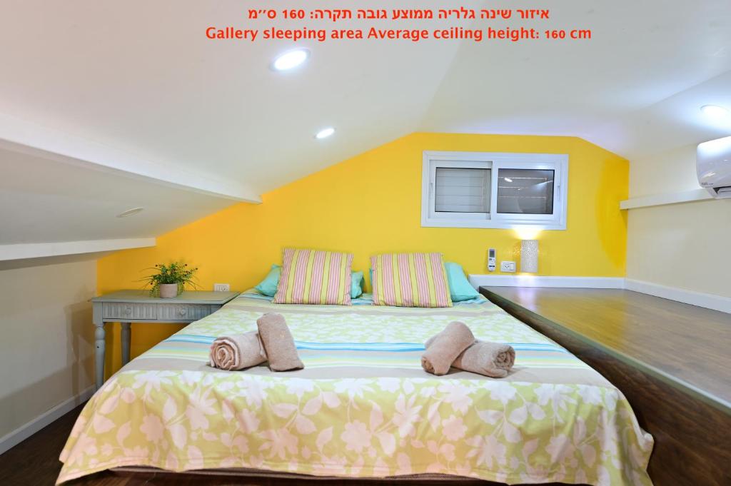 a bedroom with a large bed with two pillows on it at Sweet Home, Only 7 Min to the beach - By SEAELO EILAT in Eilat