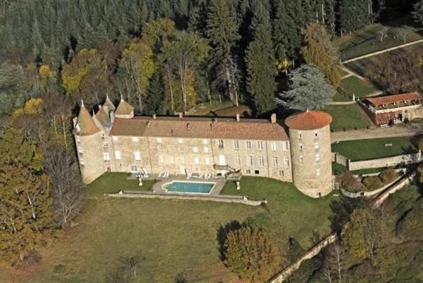 - une vue aérienne sur un grand bâtiment avec une piscine dans l'établissement Château De Vollore, à Vollore-Ville