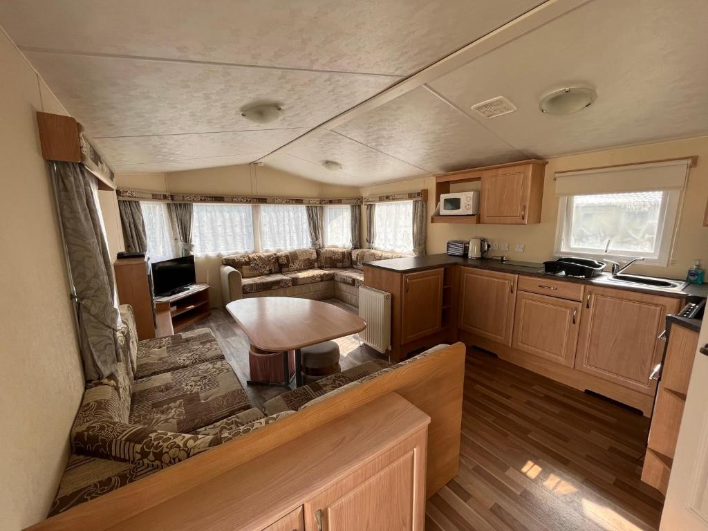 an interior view of a living room and kitchen in an rv at Contemporary Caravan at Newquay Holiday Park in Newquay