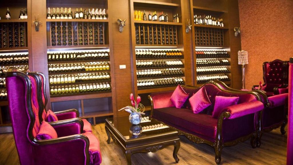 a wine tasting room with purple couches and wine bottles at Superior Room Space Available in Accra
