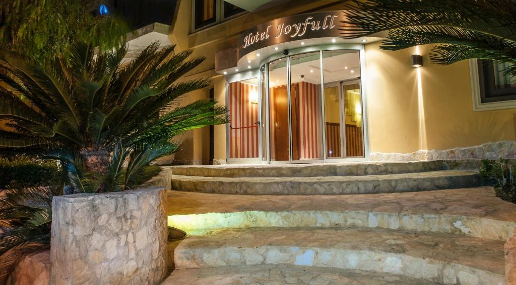 a building with a palm tree in front of it at Hotel Joyfull in Naples