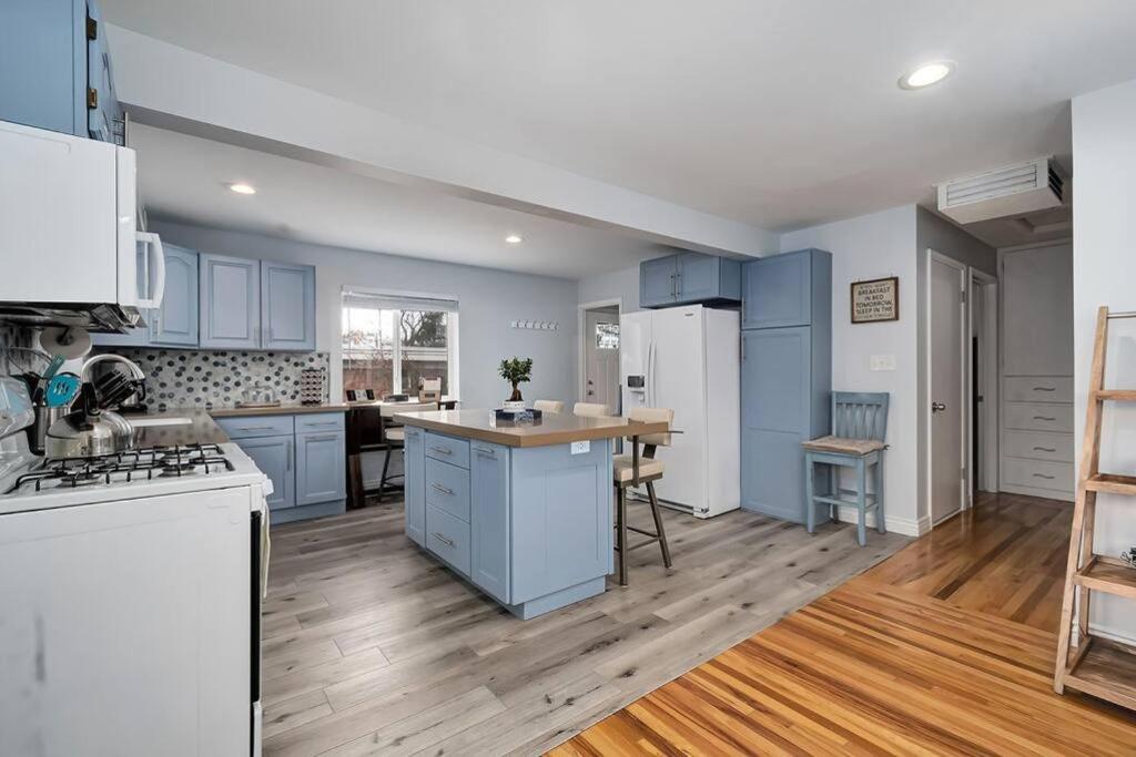a large kitchen with blue cabinets and a wooden floor at Sugar House Urban Basecamp in Salt Lake City