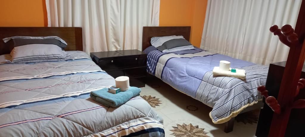 a bedroom with two beds with towels and candles at CASA HOSPEDAJE Nancy-CHINCHERO in Cusco
