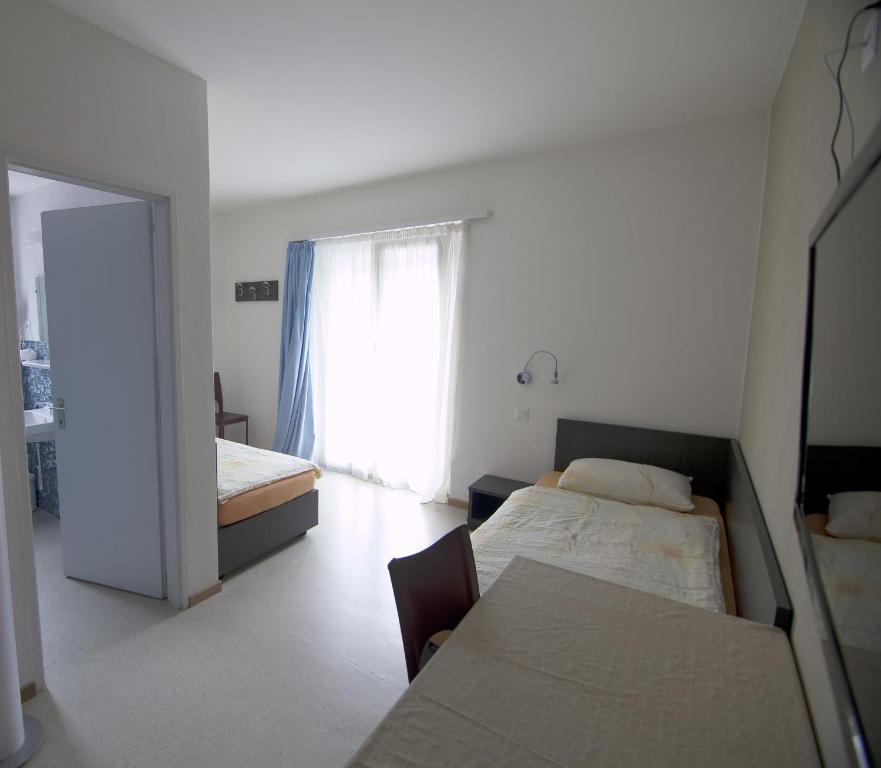 Postel nebo postele na pokoji v ubytování Albergo Elvezia